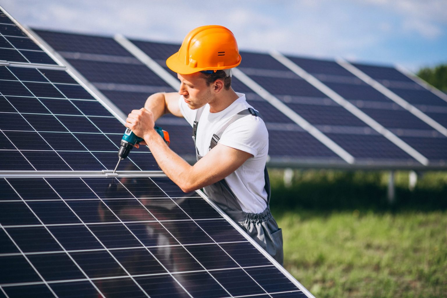 man using laptop while installing solar panels